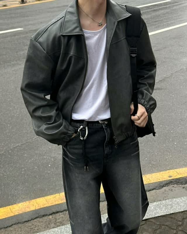Person wearing a black leather jacket, white t-shirt, and dark grey washed jeans.