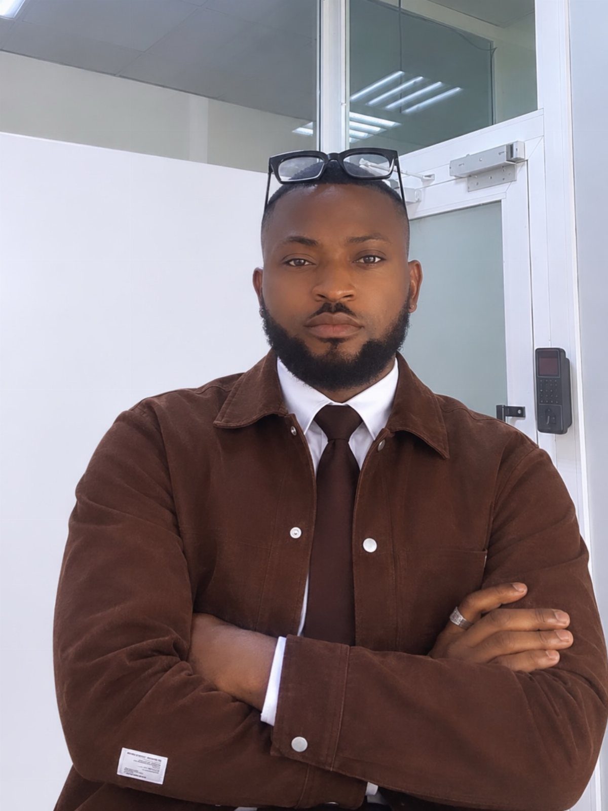 Man wearing a brown corduroy jacket with a white shirt and brown tie.