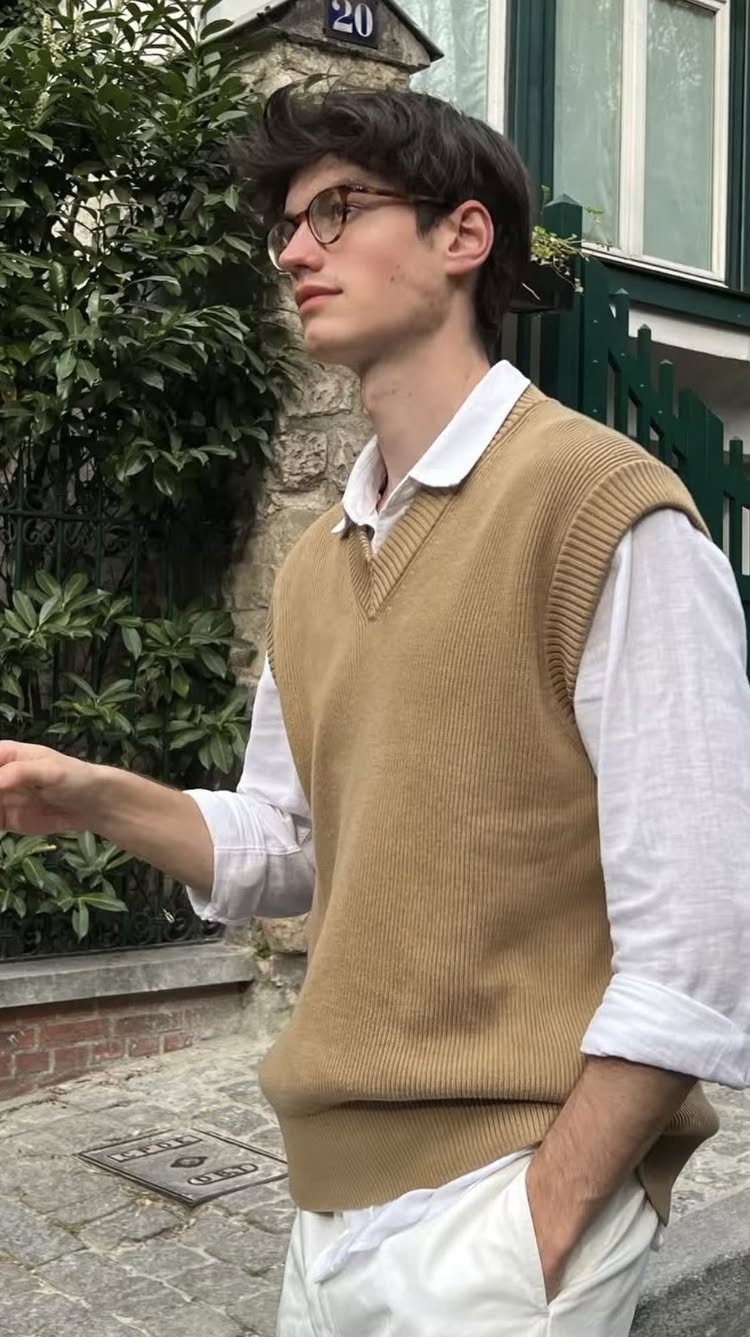 Man wearing a tan brown knit sweater vest over a white collared shirt