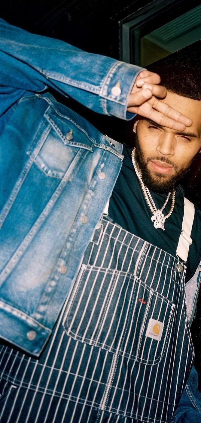 Man wearing navy blue pinstripe denim overalls and a blue denim jacket.