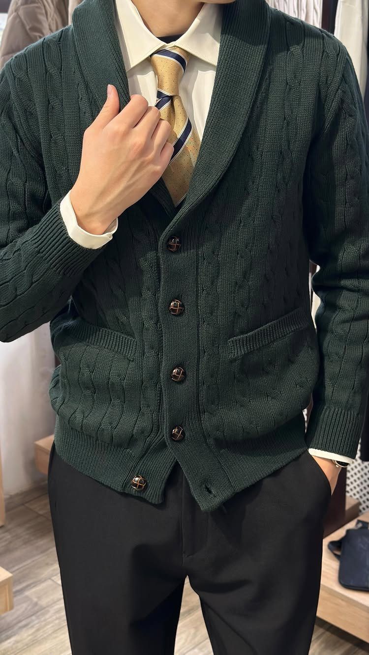 Dark green cable-knit shawl collar cardigan worn over a white shirt and tie.
