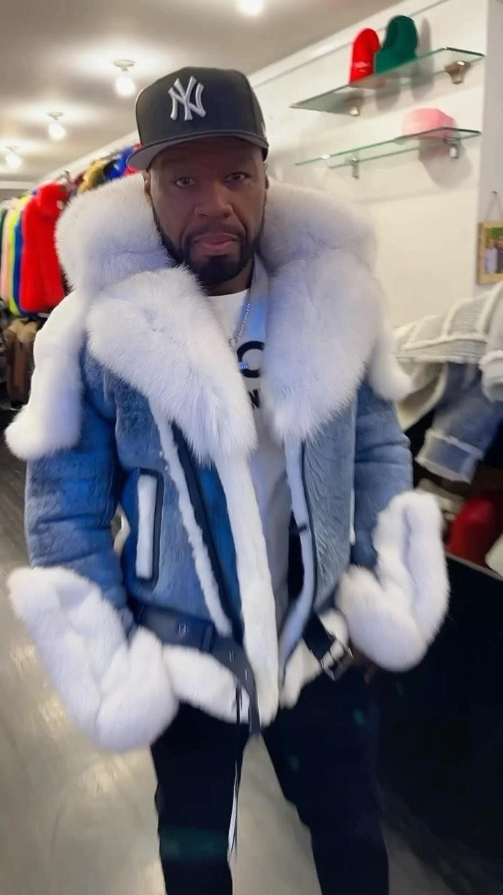 Man wearing a blue denim jacket with thick white fur trim and baseball cap