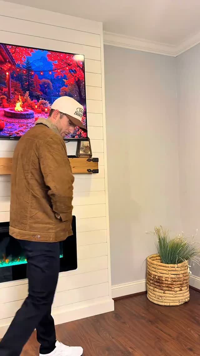 Man wearing a brown corduroy jacket, black pants, and a beige baseball cap.