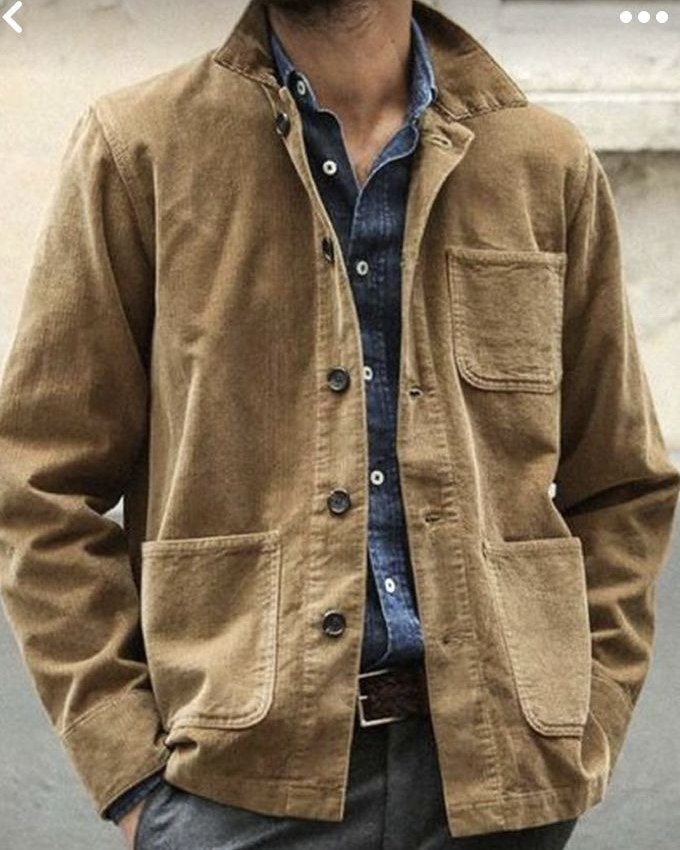 Tan corduroy jacket worn over a blue button-down shirt and grey trousers.