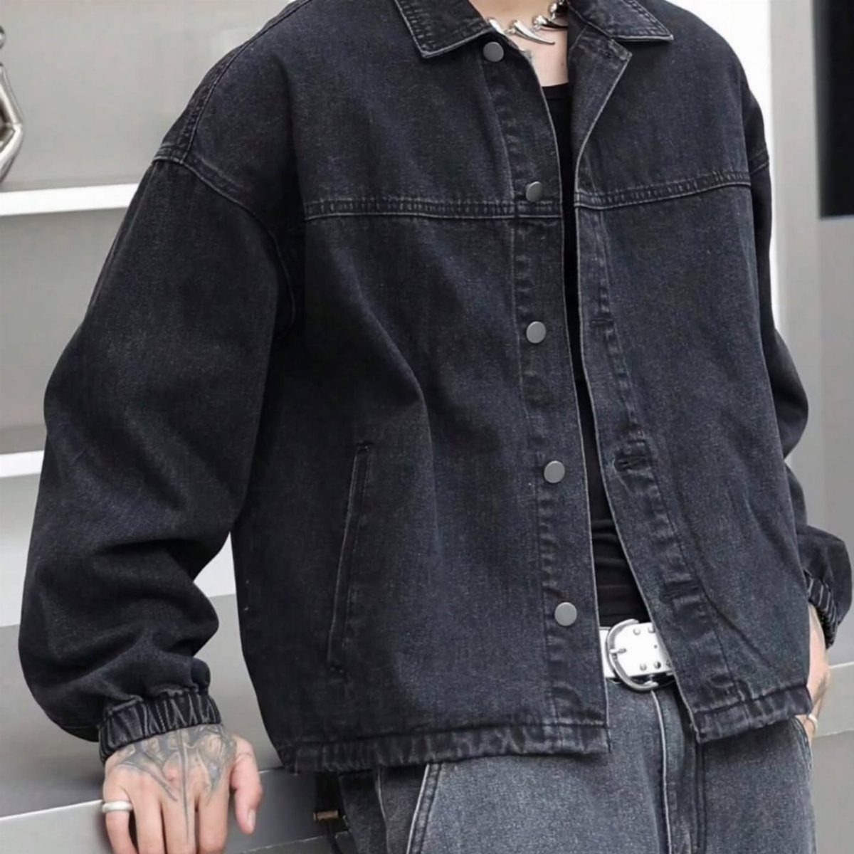 Man wearing an oversized black denim jacket, black shirt, and dark grey jeans.