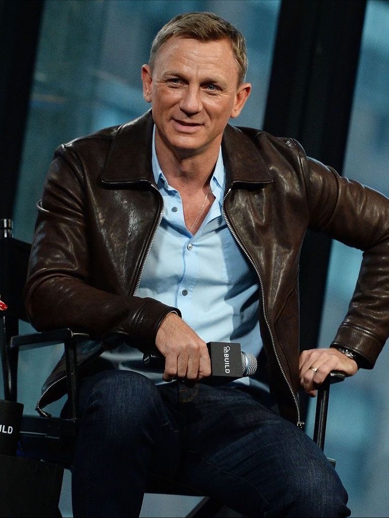 Man wearing a brown leather jacket, light blue shirt, and dark blue jeans.
