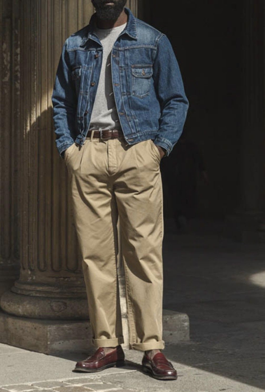 Man wearing a blue jean jacket with tan chino trousers and burgundy shoes.