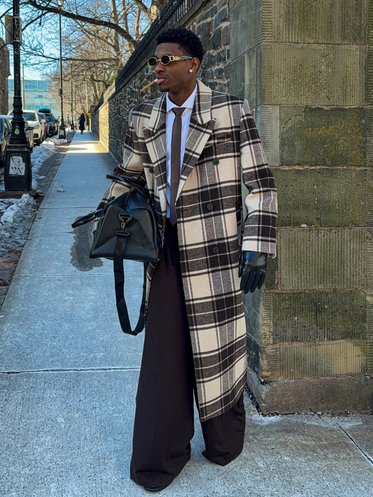 Man wearing a brown and cream plaid trench coat on a city sidewalk