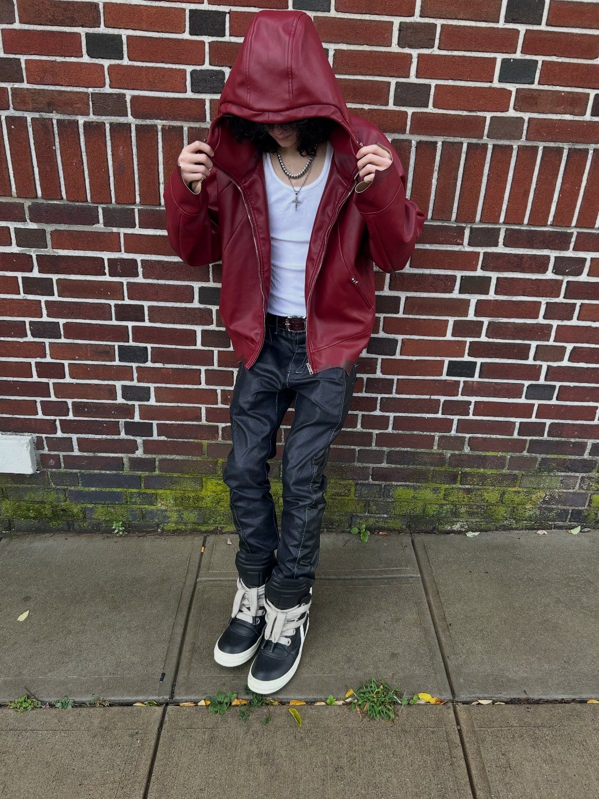 Person in a hooded red leather jacket, white shirt, and black leather pants.