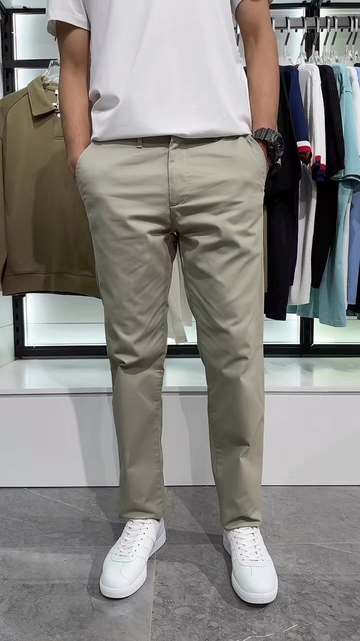 Man wearing a white t-shirt, khaki pants, and white sneakers in a store.