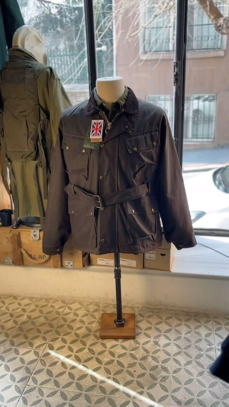 Brown belted field jacket with pockets displayed on a mannequin in a shop