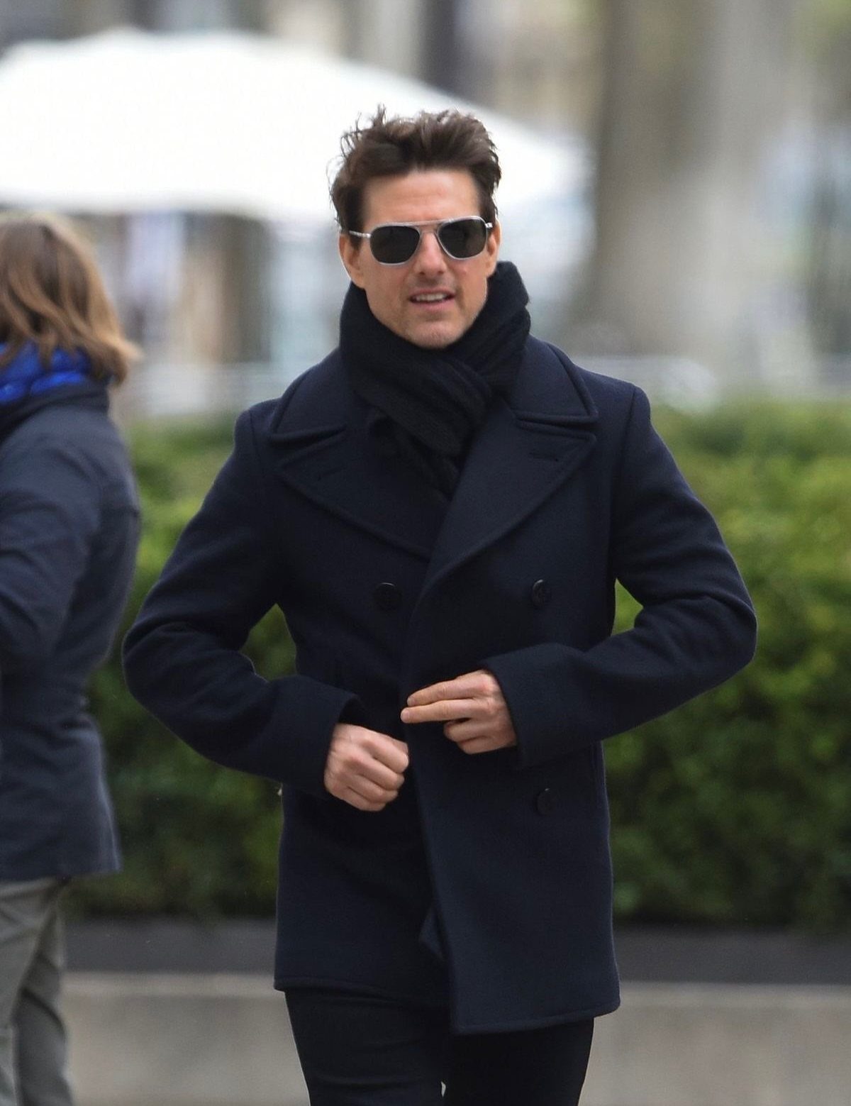 Man in sunglasses and black scarf wearing a navy double-breasted wool overcoat.