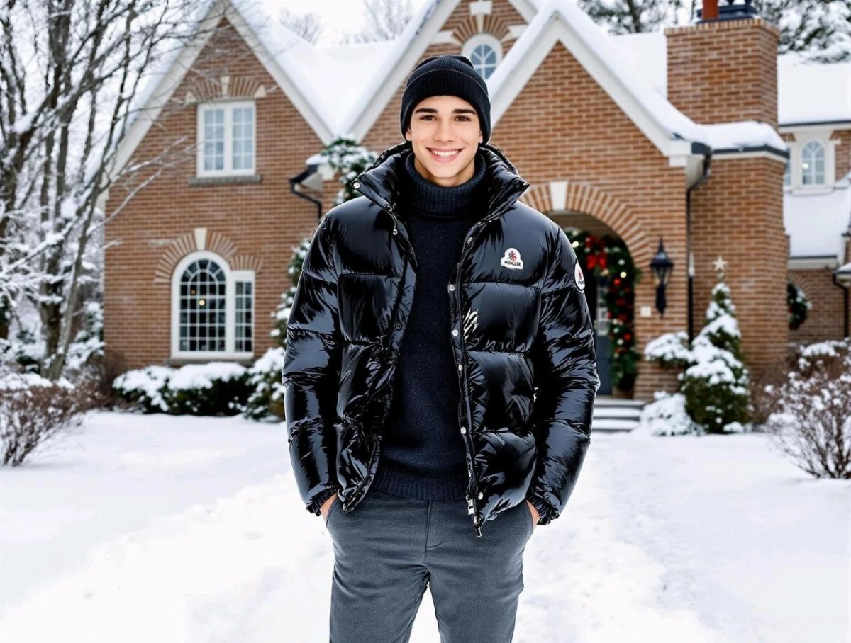 Man wearing a glossy black puffer coat and beanie in a snowy yard.