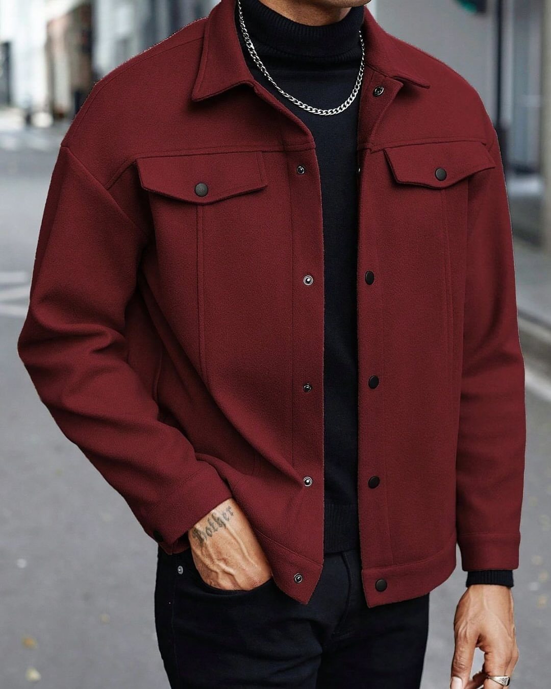 Man wearing a burgundy trucker jacket over a black turtleneck on a street.