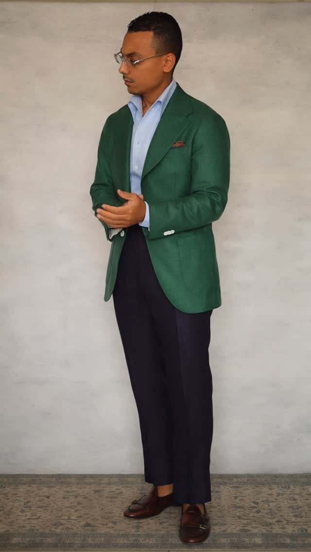 Man wearing a green blazer, light blue shirt, and navy trousers for business casual.