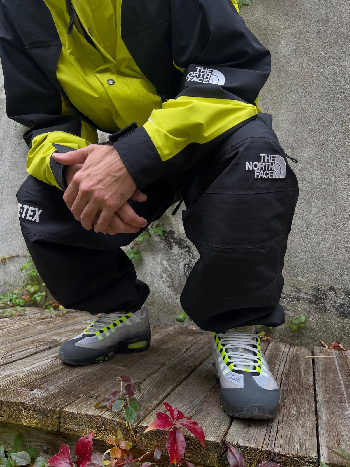 Person wearing a yellow and black technical winter jacket and black waterproof pants.