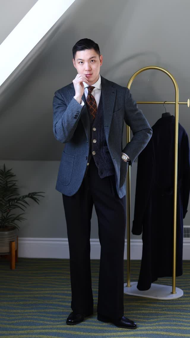 Man in a grey blazer and waistcoat posing in a professional winter outfit.